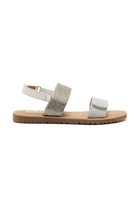 Sandali bianchi con due cinturini larghi; uno presenta un design testurizzato in argento e oro, l'altro è in argento semplice. Suola piatta color tan con grip.
