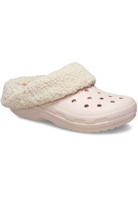 Zueco de color rosa claro con un cuello esponjoso de color crema, presenta orificios de ventilación, una suela texturizada y un diseño de puntera redondeada.