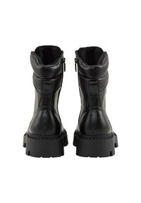 Botas negras hasta el tobillo con un diseño acolchado, que cuentan con un cierre de cremallera, suelas de goma gruesas y un forro de pelo sintético en la parte superior.
