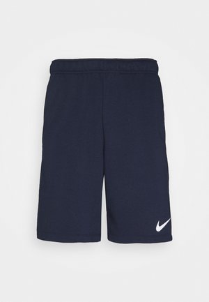 Granatowe sportowe spodenki z elastycznym pasem i małym białym logo Nike w kształcie znaku „swoosh” na lewej nodze, przedstawione na białym tle.