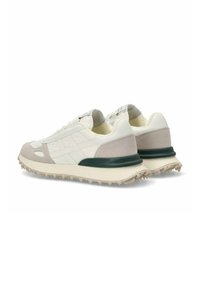 Zapatillas con una parte superior de cuero blanco y gamuza beige, suela de goma, acento verde en el talón y media suela texturizada. Presentan un diseño clásico.