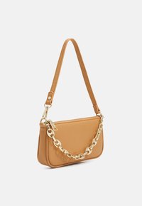 Tan-käsilaukku, joka on valmistettu sileästä tekonahasta, varustettuna lyhyellä hihnalla ja kultaketjuaksentilla. Vetoketjusuljenta hienovaraisella logot yksityiskohdalla.