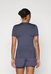 Marineblauw sportt-shirt met korte mouwen, een gladde textuur, ronde halslijn en een slim fit ontwerp, gecombineerd met bijpassende shorts.