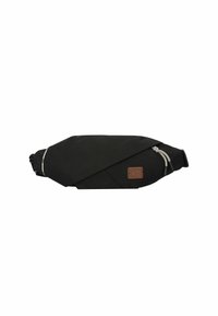 Bolso cruzado de tela negra con forma geométrica, que presenta un parche de cuero marrón, detalles reflectantes y tiradores de cremallera decorativos.
