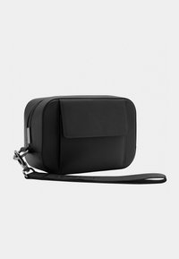 Black leather crossbody bag with a rectangular shape, featuring a front flap, zip closure, and adjustable strap. Smooth texture, minimalist design.