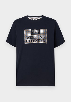 Temno modra kratka majica s kratkimi rokavi z karo obližem in krono nad besedilom "WEEKEND OFFENDER" na sredini sprednje strani.