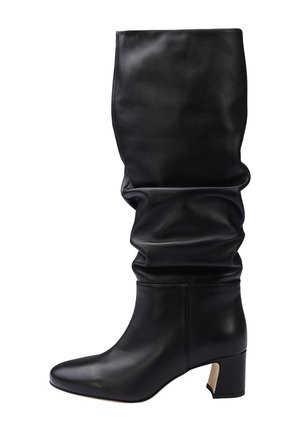 Botte en cuir noire mi-mollet décontractée avec bout arrondi et talon bloc, vue de côté sur fond blanc.