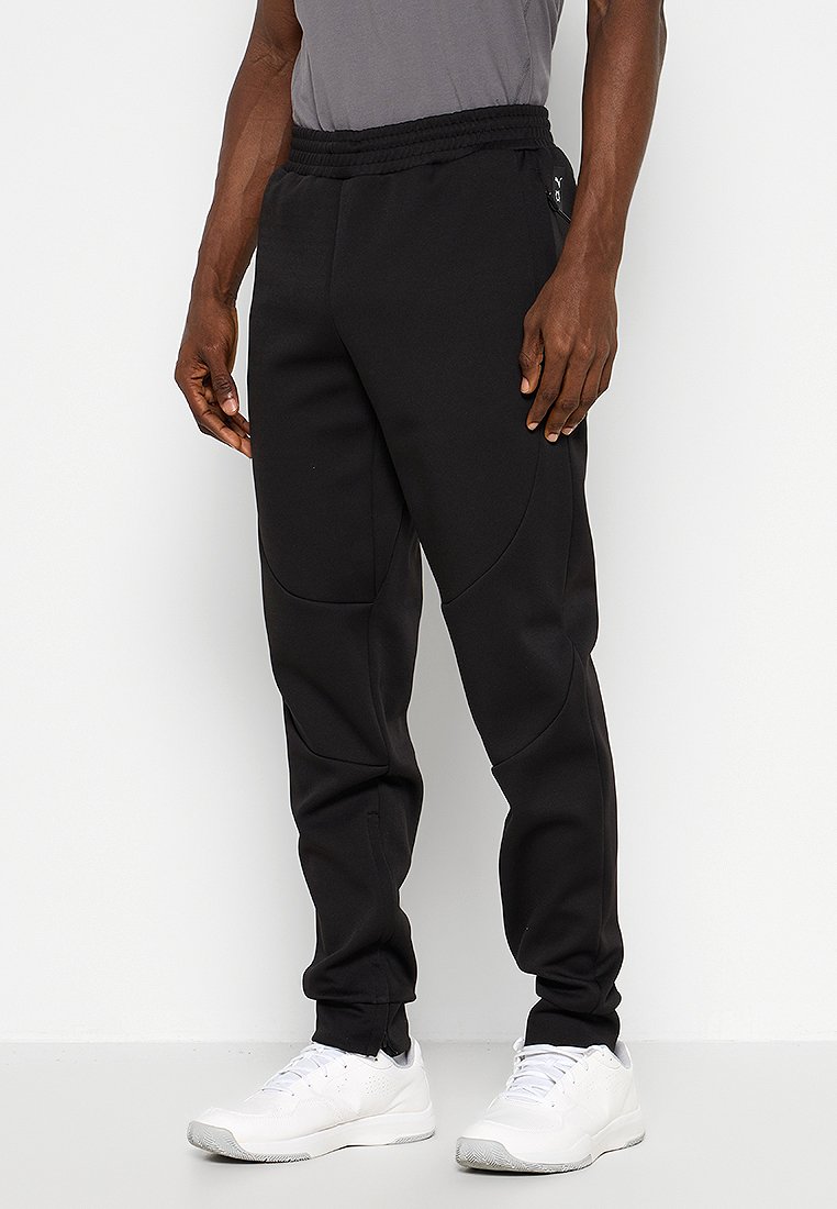Pantalons de jogging noirs avec une coupe fuselée, taille élastique et poches latérales. Fabriqués en tissu doux, avec des coutures arrondies pour un look moderne.