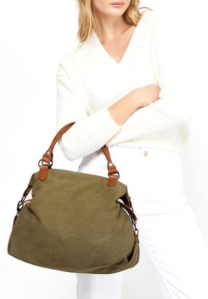 Olive green canvas handbag with brown leather accents and adjustable straps. Soft texture, large size, and rounded shape for easy carrying.