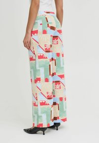 Pantalons taille haute à motifs dans des couleurs pastel avec des formes géométriques, dotés d'une poche latérale et d'un tissu doux.