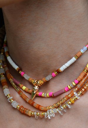Collier multi-couches avec des perles orange, rose et blanches, des accents dorés et un pendentif en forme de pique doré décoratif. Différentes formes et textures de perles.