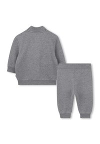 Tylny widok dwuczęściowego kompletu dla małego dziecka, składającego się z szarego sweterka z długim rękawem oraz pasujących szarych spodni z elastycznymi mankietami.