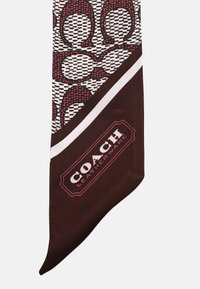 Foulard in seta con un motivo geometrico maroon e bianco caratterizzato da motivi circolari. Include il logo Coach Leatherware nell'angolo inferiore.