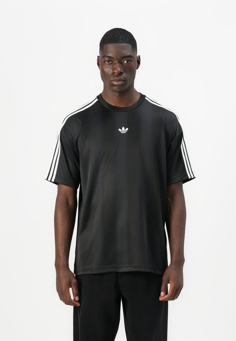 Μαύρο αθλητικό μπλουζάκι με κοντά μανίκια, διαθέτει λευκές τρεις ρίγες στους ώμους και μικρό λευκό λογότυπο στο στήθος. Λεία υφασμάτινη επιφάνεια.