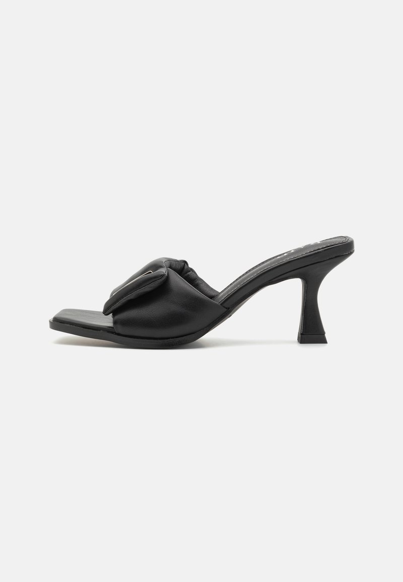 Sandale mule noire à talon haut avec bout carré, bride rembourrée avec un design à rabat et talon kitten évasé.