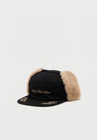 Svart cap med faux fur øreklapper, gullbrodert tekst "Don't Waste Culture" og dekorativ olivengren-design på visiret.