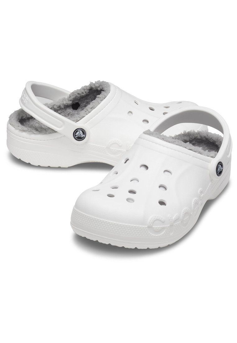 Witte klompen met een textuurafwerking, voorzien van een zachte grijze bontvoering, afwateringsgaten en een achterriempje voor een veilige pasvorm. Logo aan de zijkant.