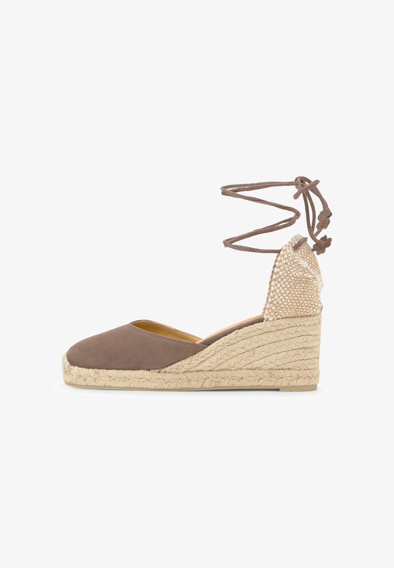 Espadrille compensée marron à bout fermé avec semelle en jute tressée et liens à nouer autour de la cheville, comprenant un contrefort de talon tissé et des extrémités nouées sur les lanières.
