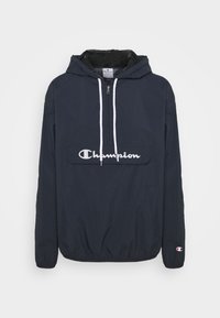 Marinefarbener Windbreaker mit einer Fronttasche, Halb-Reißverschluss, verstellbarem Kapuze, weißen Kordeln und einem auffälligen weißen "Champion"-Logo.