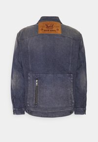 Jeansjacka i mörkblått med en urtvättad finish. Har en läderlogotyp på ryggen och en dragkedjeficka på sidan.