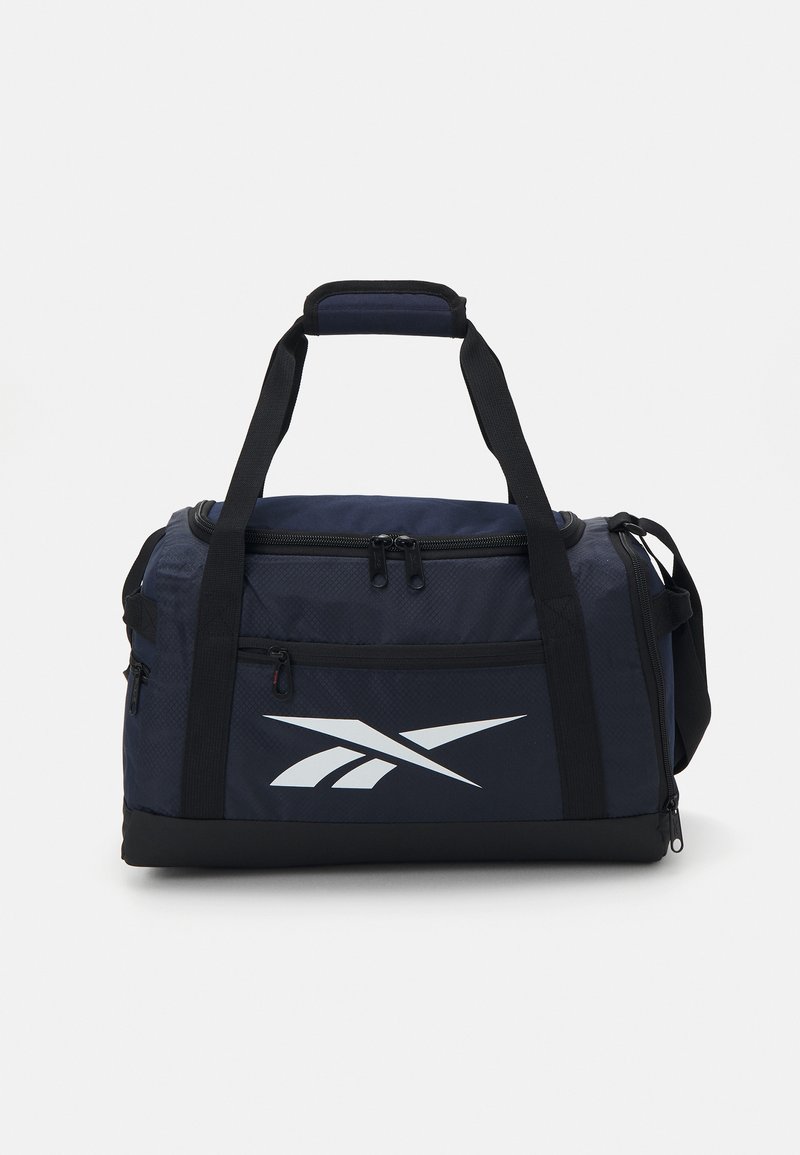 Sac de sport bleu marine avec une texture, arborant un logo blanc, des compartiments à double zip et des poignées renforcées pour plus de durabilité.