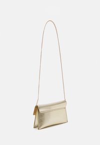 Small metallic gold shoulder bag with a thin chain strap and triangular side gussets on a white background.