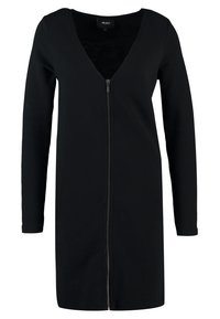 Robe noire à manches longues avec un décolleté en V et une fermeture éclair à l'avant. Confectionnée dans un tissu texturé, elle présente une coupe ajustée et une longueur jusqu'aux genoux.