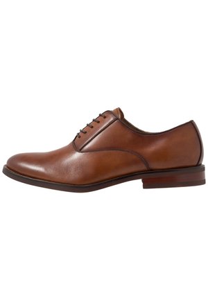 Brauner Herrenohrenschuh aus Leder mit geschlossener Schnürung, glatter Oberfläche, niedrigem gestapeltem Absatz und abgerundetem Zehenbereich, seitlich dargestellt.