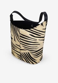 Bolsa marrón con patrones de hojas negras, hecha de material suave. Cuenta con una sola correa de cuero y un cierre superior seguro.