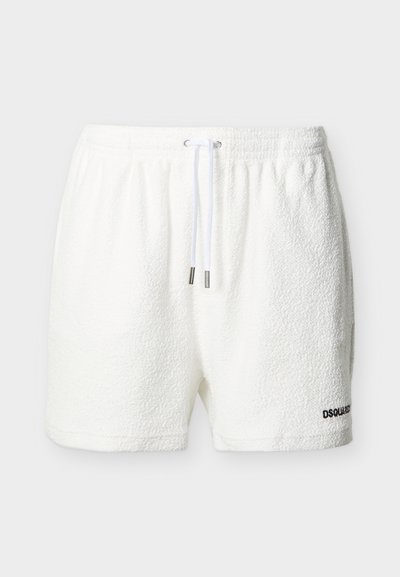 Shorts en éponge blanche avec taille élastique et cordon blanc, présentant un petit logo en texte noir sur l'ourlet de la jambe gauche.