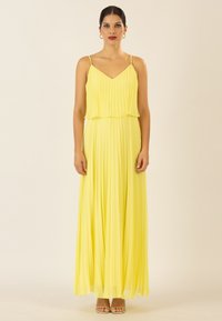 Gelbes gefaltetes Maxikleid mit geschichtetem Oberteil, Spaghettitr�ägern und fließendem Rock. Aus weichem, leichtem Stoff mit glatter Textur.