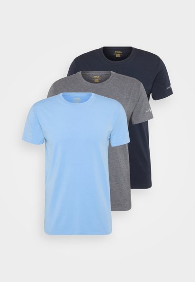 Três t-shirts de mangas curtas: azul claro, cinza e azul marinho escuro. Feitas de tecido suave, com decotes redondos e designs simples e limpos.