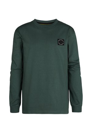 Camiseta de algodón verde de manga larga con un cuello redondo, puños acanalados y un parche de logo cuadrado negro en el lado izquierdo del pecho.
