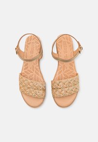 Geflochtene beige Sandalen mit strukturierten Riemen, einer glatten Sohle und einem dekorativen goldenen Akzent. Verstellbarer Knöchelriemen mit einer Schnalle.