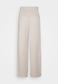 Jasnobeżowe spodnie o szerokich nogawkach wykonane z miękkiego, elastycznego materiału, z elastycznym pasem i gładką, gładką powierzchnią bez zdobień.
