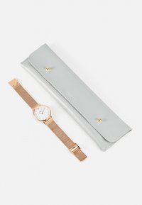 Montre avec bracelet en maille rose gold et cadran blanc, accompagnée d'un étui en cuir gris avec fermoir à pression et logo embossé.
