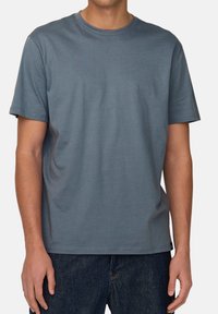 Short-sleeve crewneck t-shirt in soft, lightweight blue fabric. Simple design with double-stitched hems and a relaxed fit.