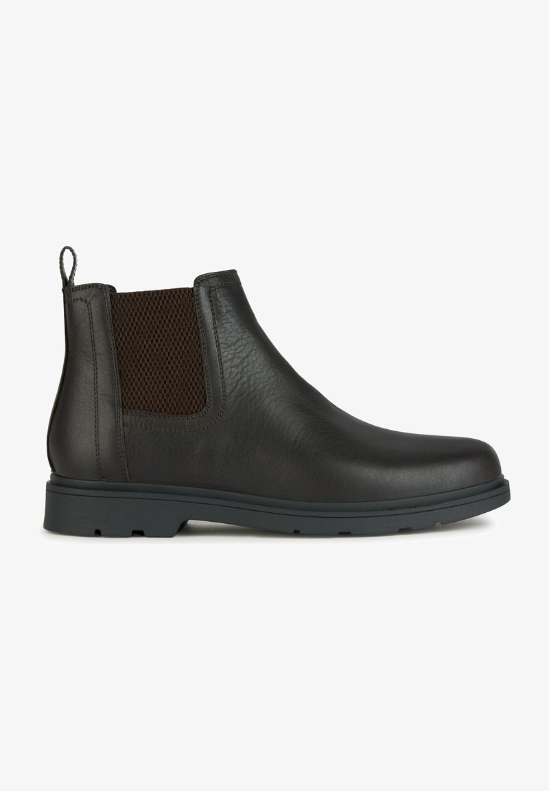 Bota Chelsea de cuero marrón con un panel de malla texturada, una lengüeta y una suela de goma duradera, diseñada para facilitar su uso y proporcionar comodidad.