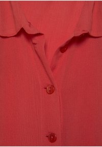 Blusa rossa a trama con colletto, dotata di chiusura frontale con bottoni abbinati e un sottile motivo a coste.