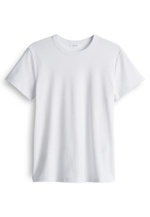 T-shirt en coton blanc avec un col rond et des manches courtes. Texture douce, coupe droite, sans logos ni motifs visibles.