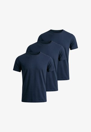 Tre enkle mørkeblå t-shirts med korte ærmer og rund hals stablet i en trappestillet opstilling på en hvid baggrund.