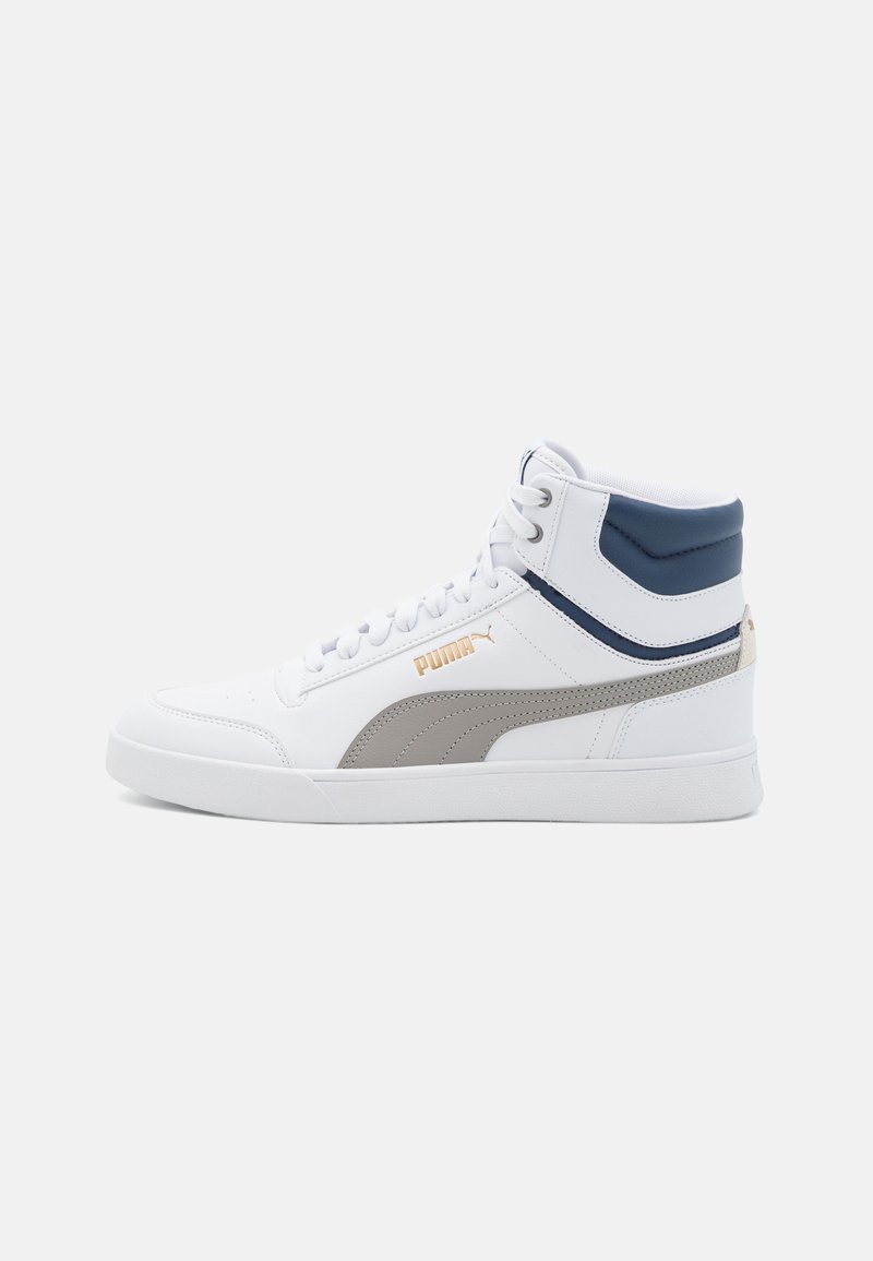 Baskets montantes blanches Puma avec bande grise, détails bleu marine au niveau du col et logo doré sur le côté, présentées de profil gauche sur un fond uni.