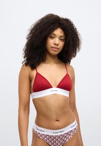 Ερυθρό τριγωνικό σουτιέν με ραβδώσεις και λευκή ταινία με το λογότυπο "Calvin Klein"; ταιριαστό μπικίνι με σχέδιο και λευκή μέση.