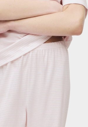 Lyserød stribet pyjamastop med korte ærmer, kombineret med pyjamabukser med elastisk talje i matchende lyserød. Blød stoftekstur synlig.