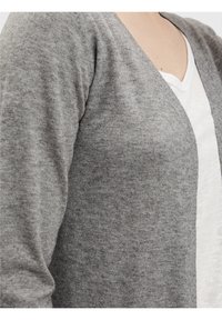 Gilet gris en tissu tricoté doux, avec des manches longues et un design en v. Il a une texture lisse et aucun motif visible.