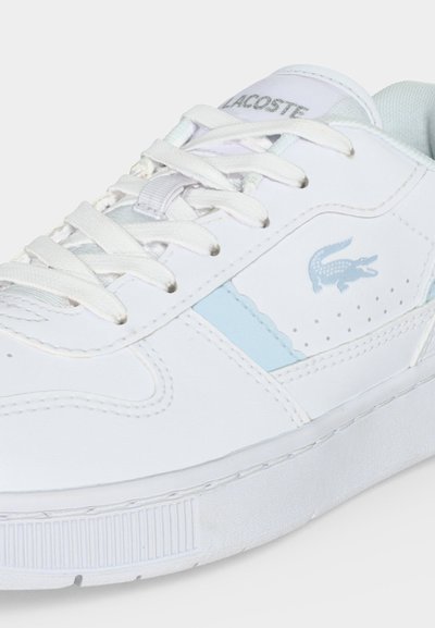 Бял кец Lacoste със светлосини акценти, бели връзки и логото на крокодила Lacoste отстрани и на езика.