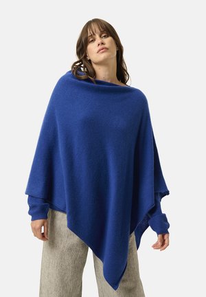 Blå poncho lavet af blødt stof, med en bred halsudskæring og løs pasform. Designet er asymmetrisk med lange ærmer og ribbede manchetter.
