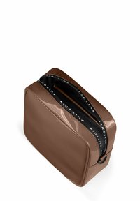 Braune Lackledertasche mit rechteckiger Form, Reißverschlussverschluss und schwarzer Innenauskleidung mit wiederholtem weißen Text. Glatte Textur.