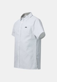 Light blue short-sleeve button-up shirt with a chest pocket and small black and white "Seaside" logo patch.