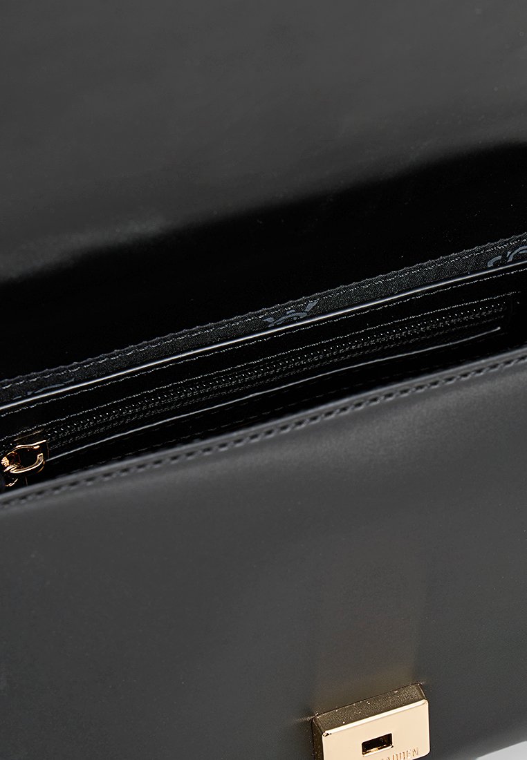 Schwarze Lederhandtasche mit glänzender Oberfläche, ausgestattet mit einem goldfarbenen Hardwareverschluss und einem Reißverschlussfach innen zur Organisation.